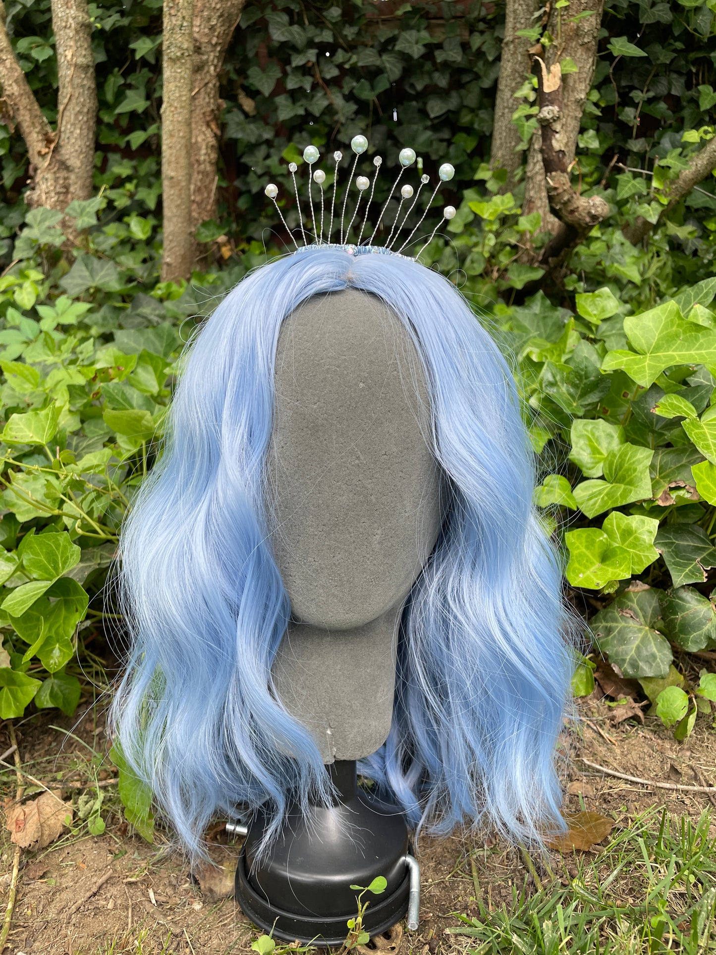 Blue celestial tiara crown on a model with blue hair in forest setting.