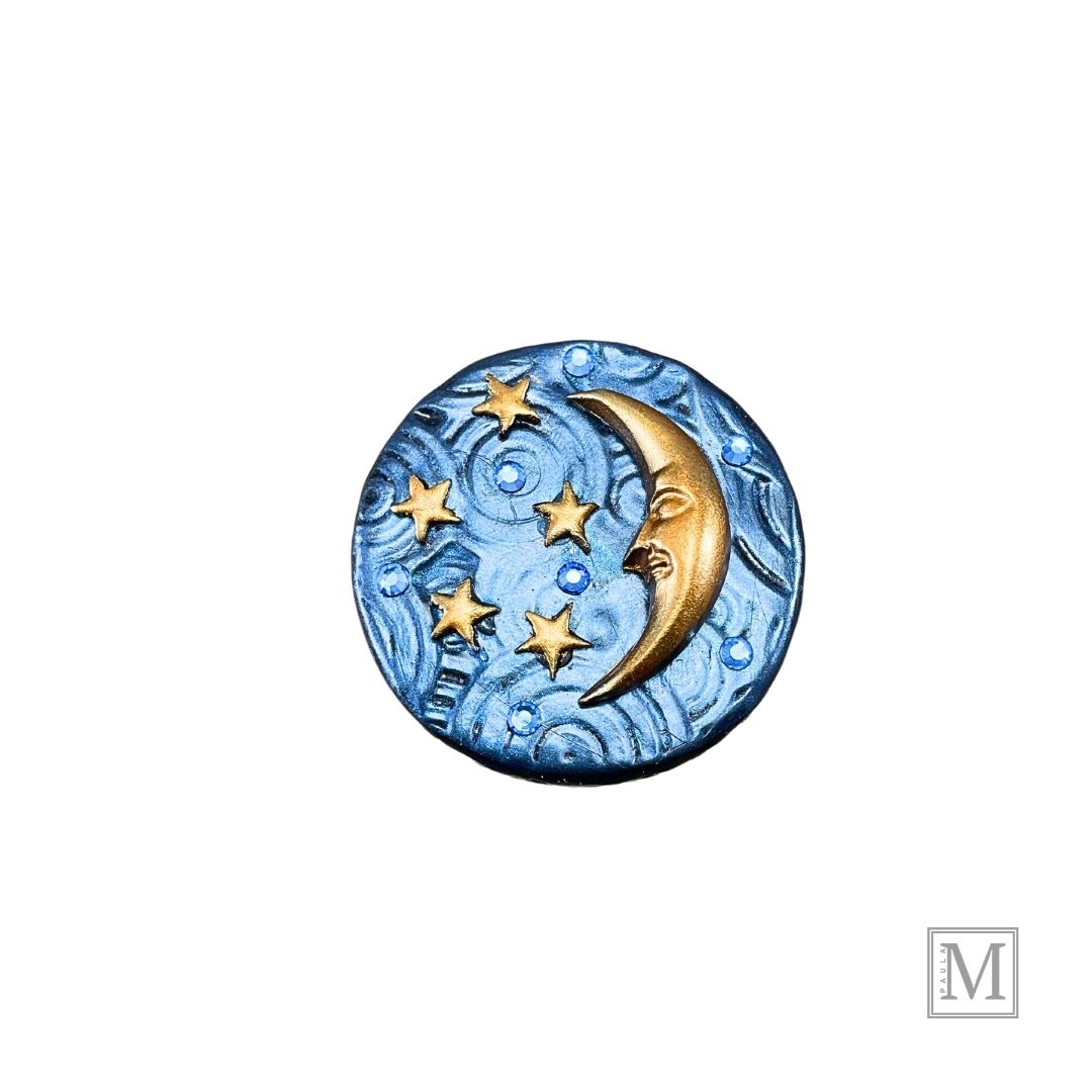 A lid to a 4oz candle tin with deocrative lid. Lid is blue textured polymer clay with gold crescent moon, stars an blue crystals.
