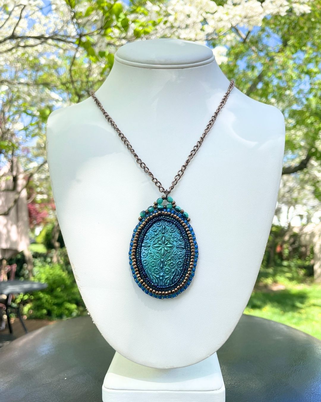 Blue medieval necklace in garden setting