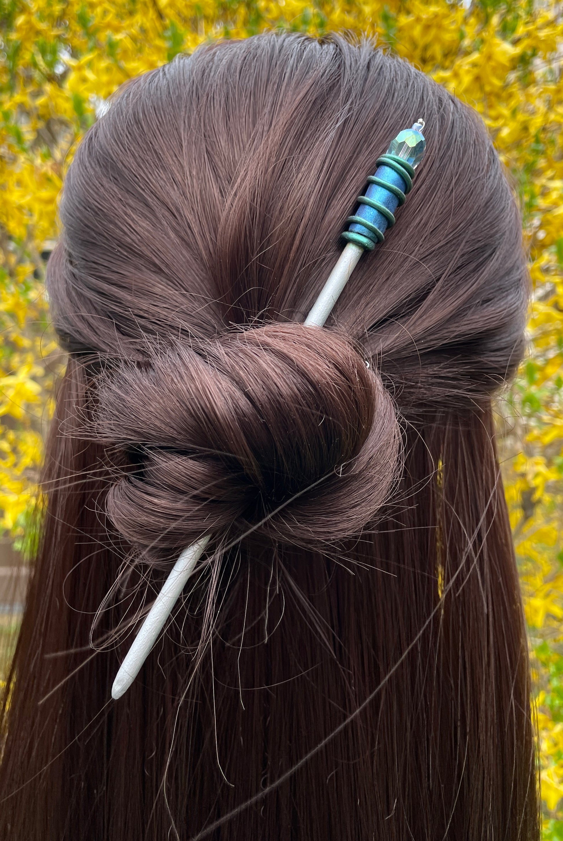 Model wearing Silver painted wood Hair stick with blue and green spiral clay hand painted details with green AB crystal.