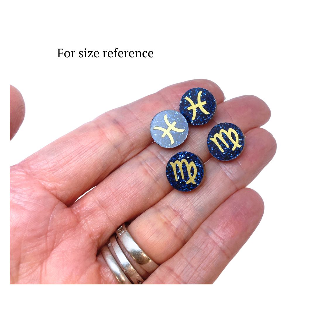 round acrylic earrings held in hand for size reference