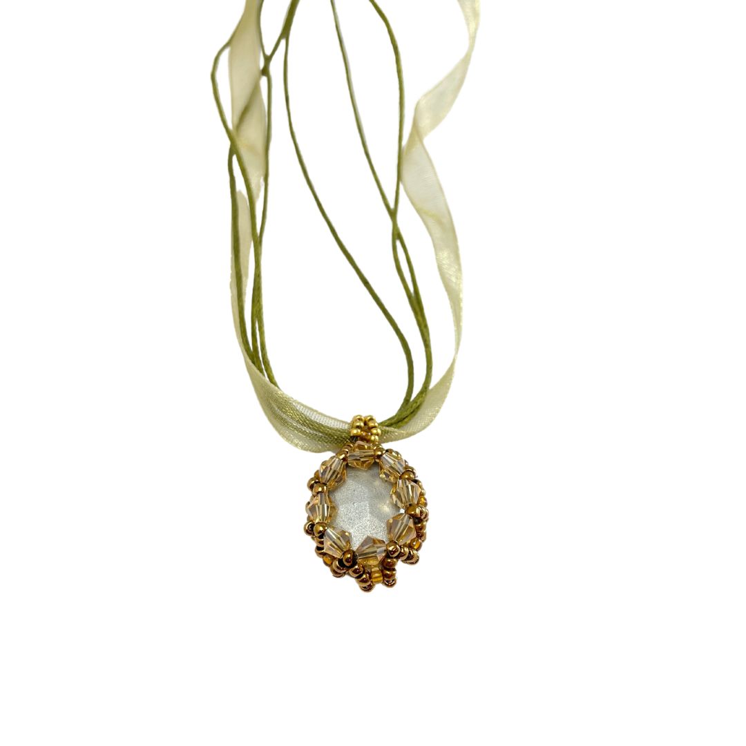 Back of yellow beaded crystal necklace with organza ribbon cord against a white background.