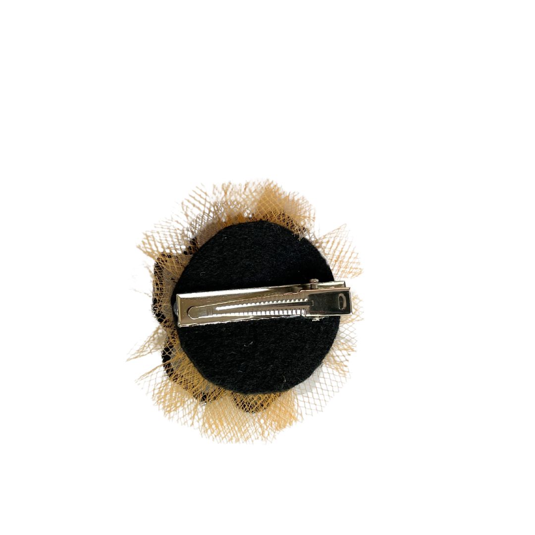 Back of Black flower applique hair clip with orange tulle behind the black flower and an alligator clip.