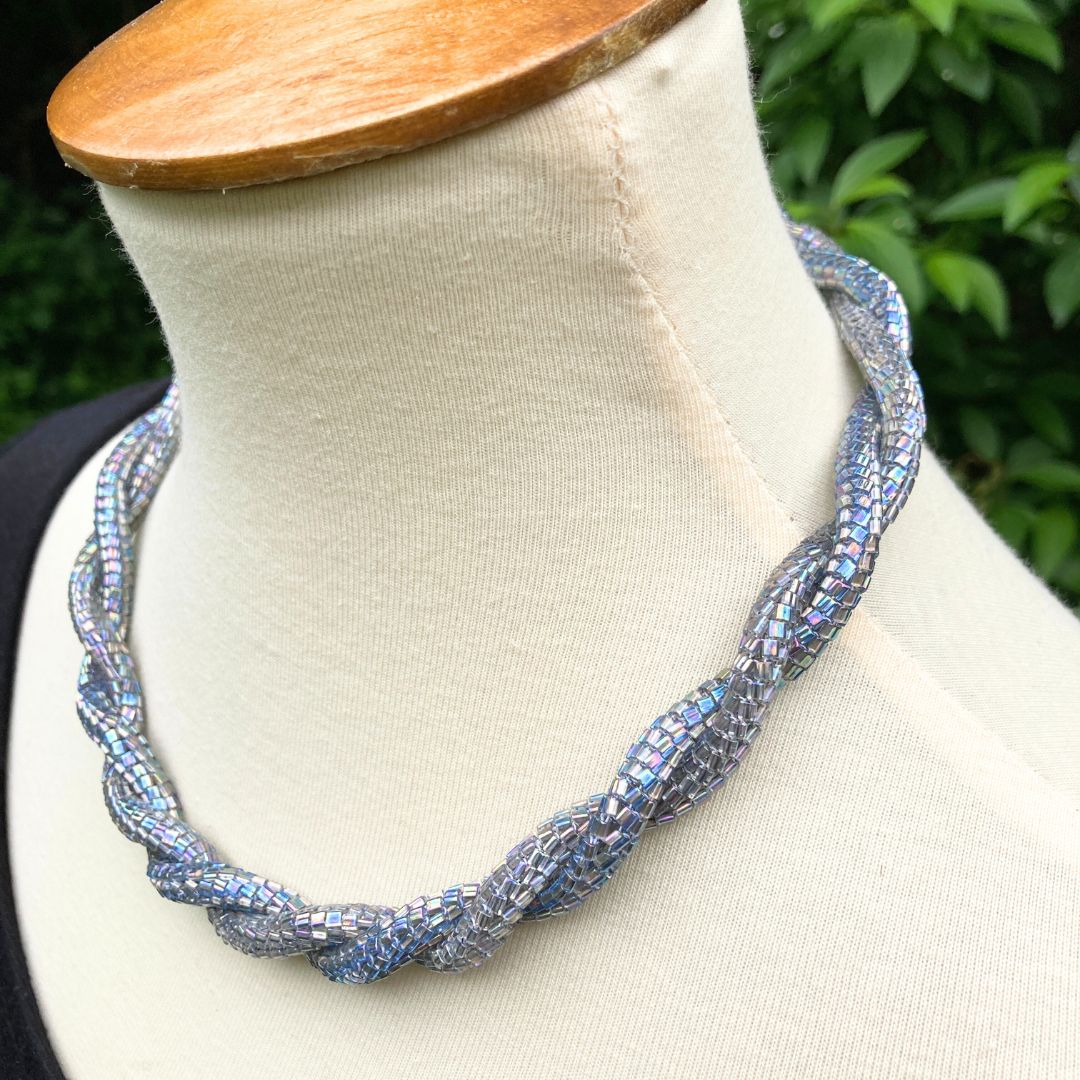 Left profile view of Beaded rope necklace on a model in a garden setting