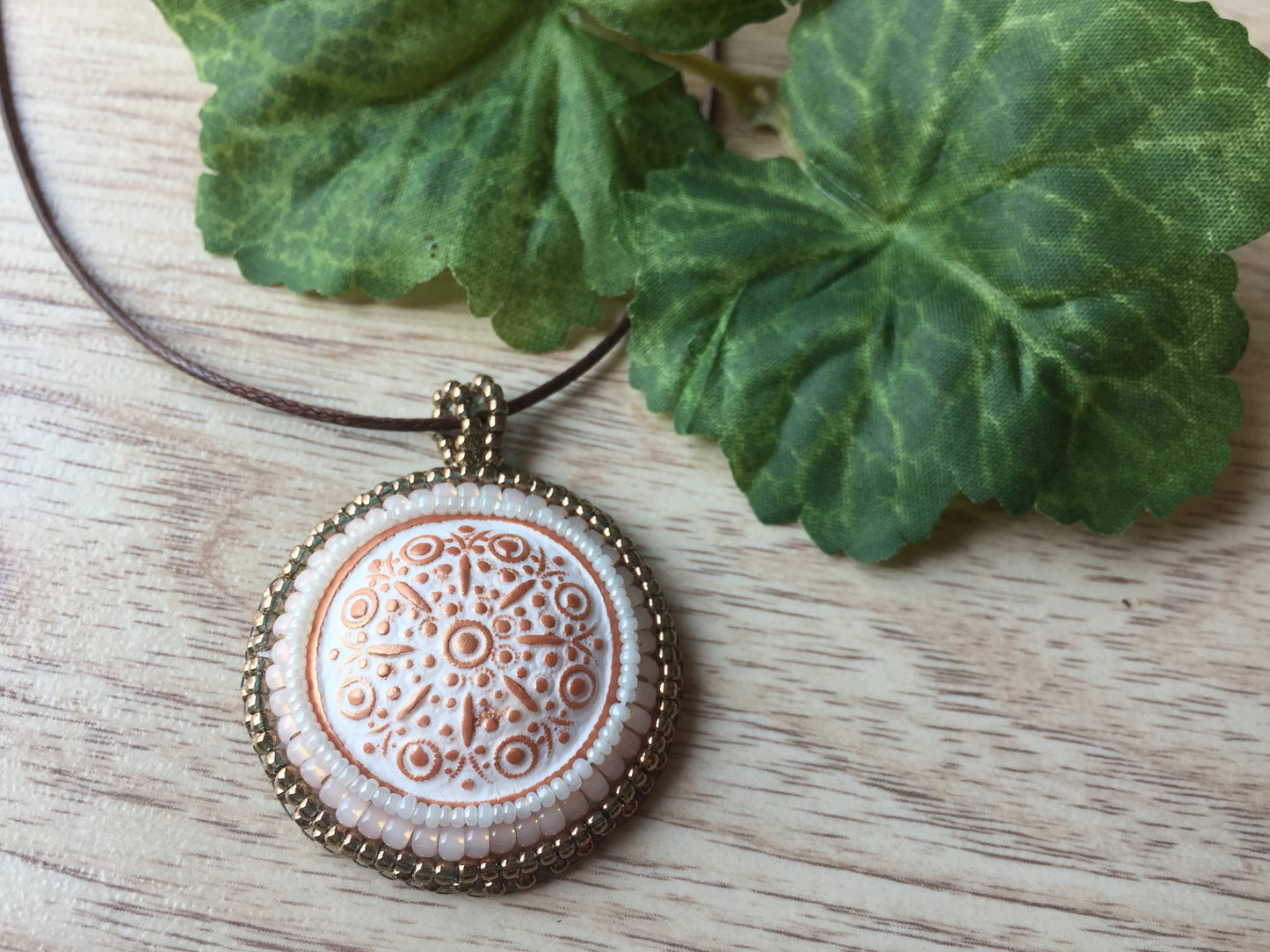 copper and white floral round pendant with plant