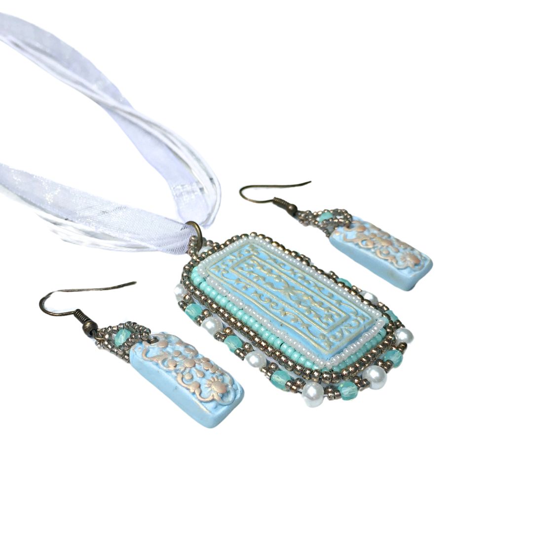 side profile of duck egg blue floral beaded necklace jewelry set on white background.