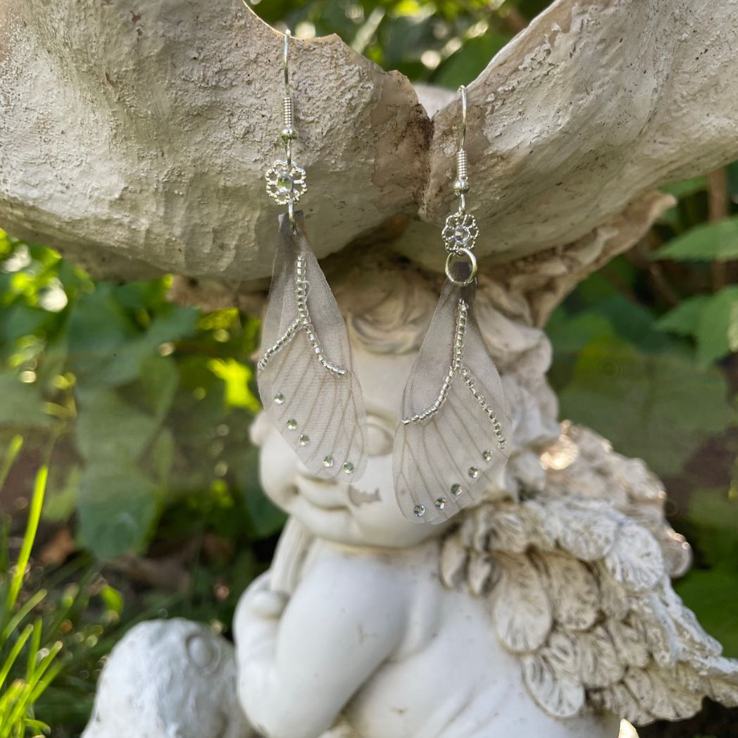 Silver beaded gray sheer fabric butterfly wing earrings with crystals and a flower bead connecting to the ear wires.