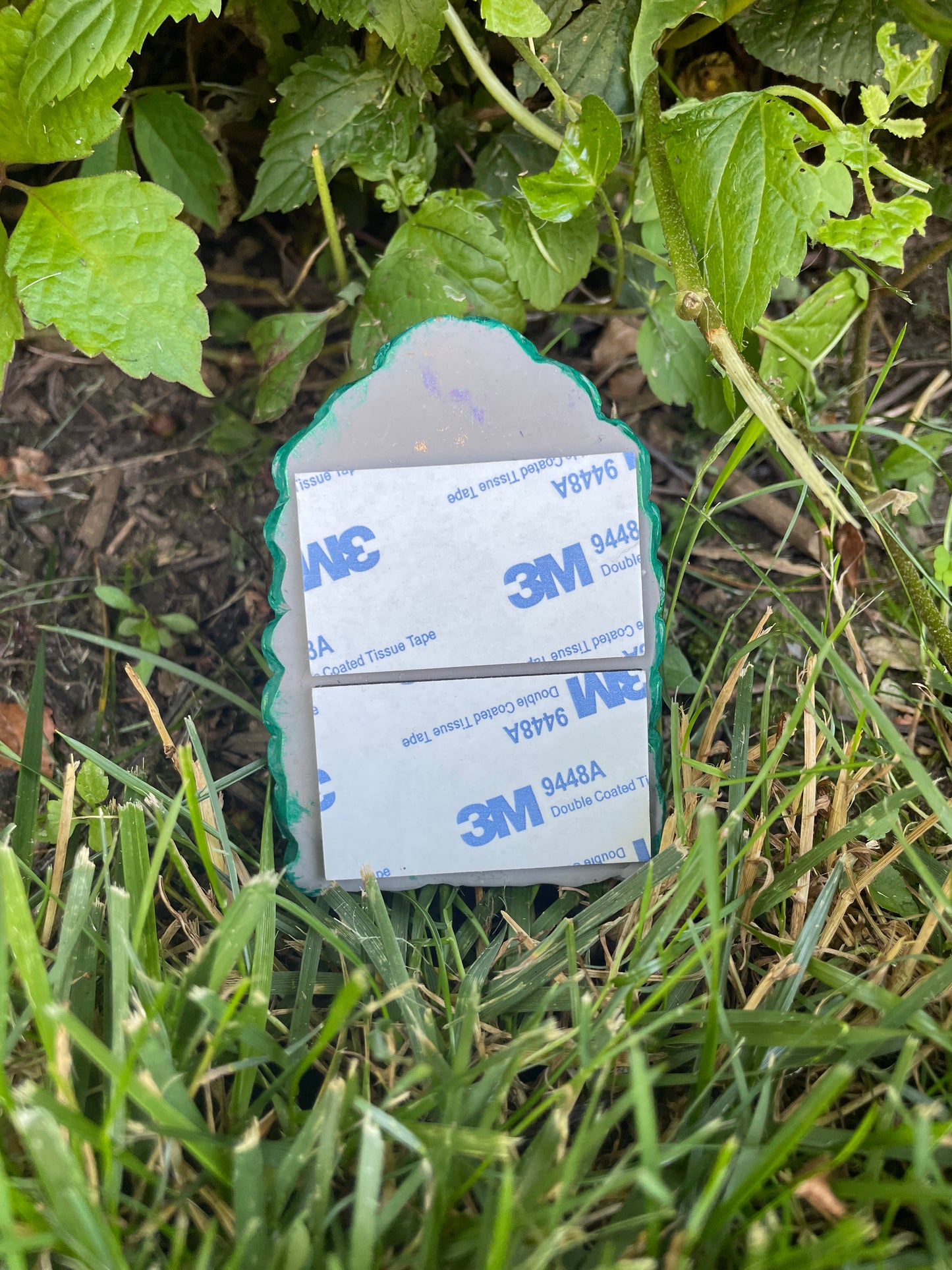Back of fairy door with foam sticky pad. Displayed in a grassy area.