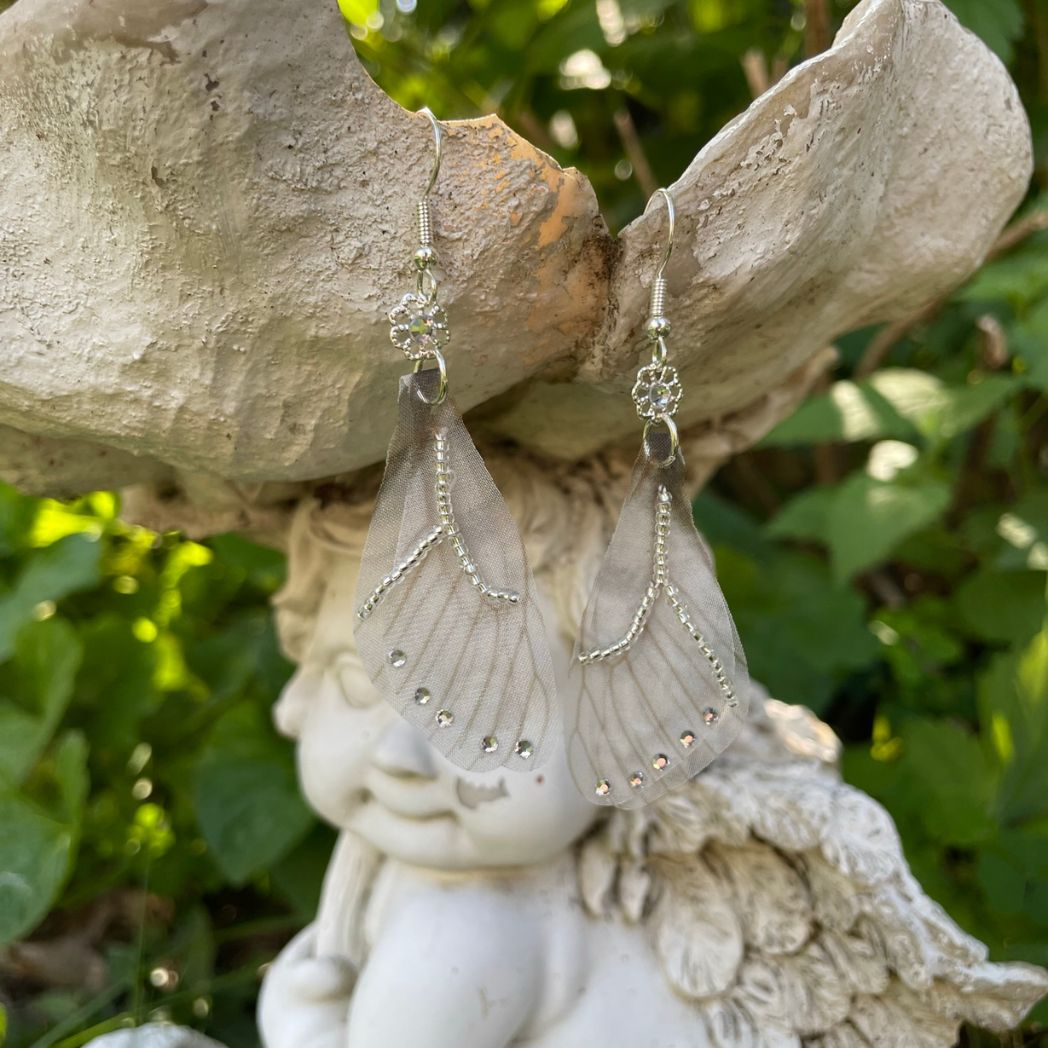 Silver beaded gray sheer fabric butterfly wing earrings with crystals and a flower bead connecting to the ear wires.