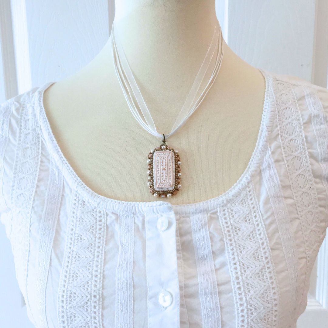 model wearing copper and white floral beaded necklace.
