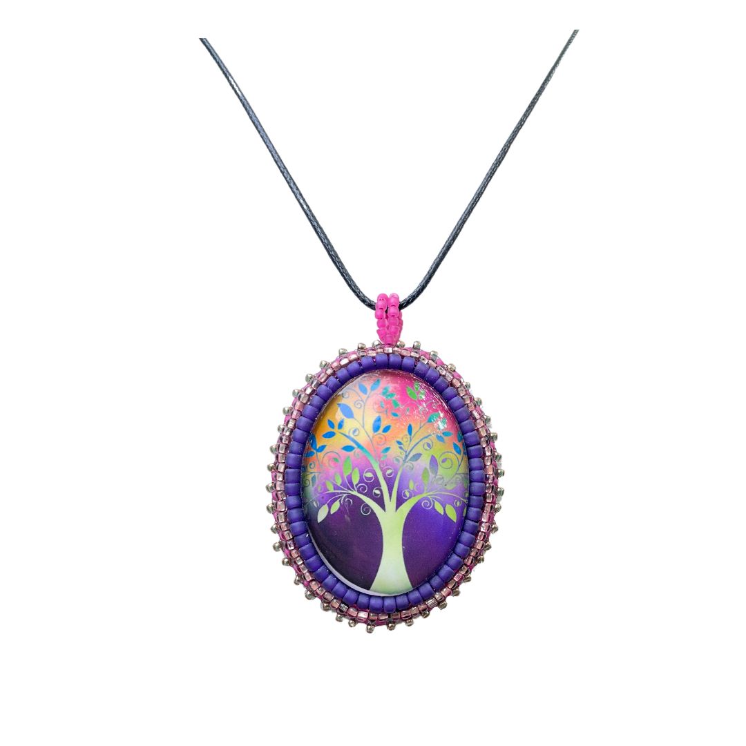 Oval pendant with whimsical tree with purple, red and pink background with pink and purple glass seed bead edging on a black cord necklace.