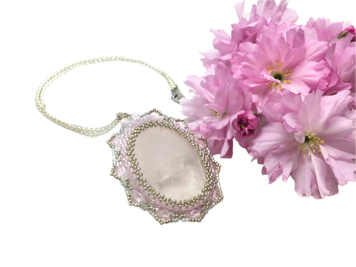 Back of rose quartz pendant with pink blossoms.