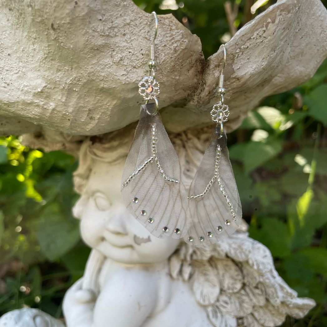 Silver beaded gray sheer fabric butterfly wing earrings with crystals and a flower bead connecting to the ear wires.