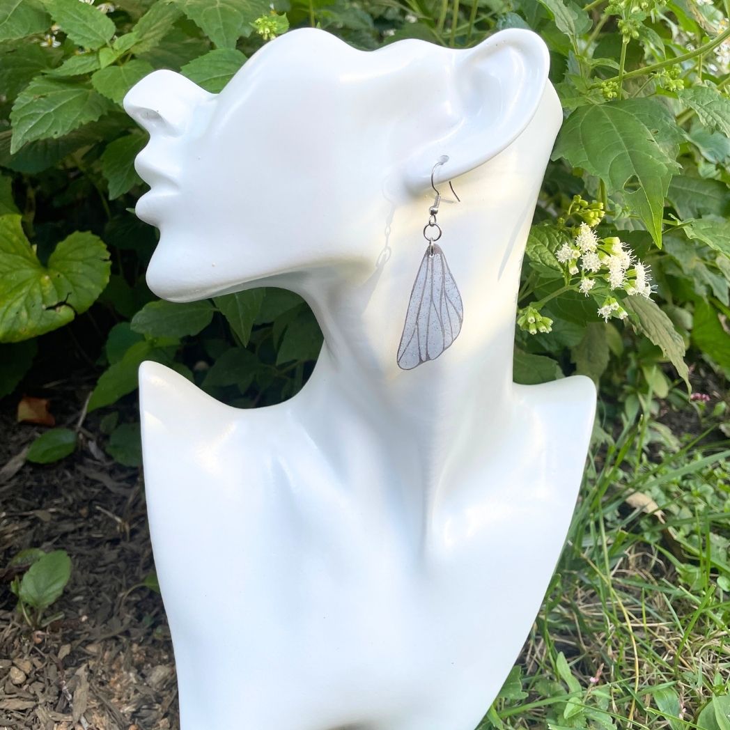 Blue gray small wing earrings on a model bust.
