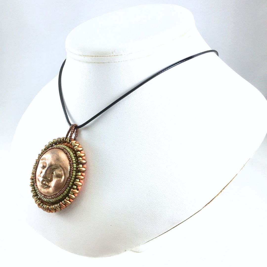 golden sun pendant on display bust