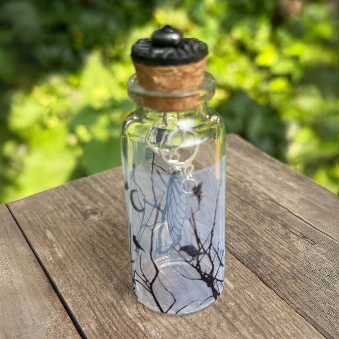Glass bottle with cork lid on a wooden surface with a blurred green background