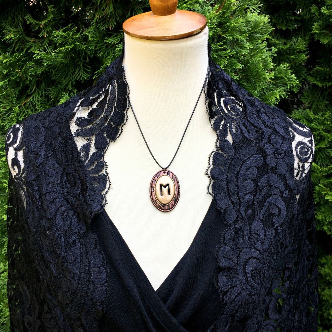Model wearing ehwaz rune symbol pendant in garden setting
