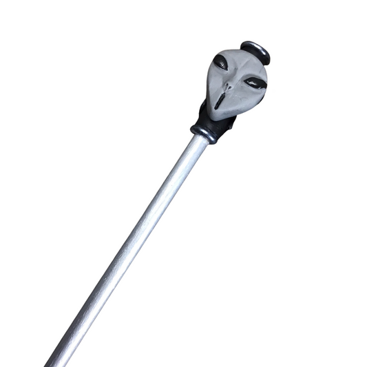 Silver hair stick with gray polymer clay alien head at one end.
