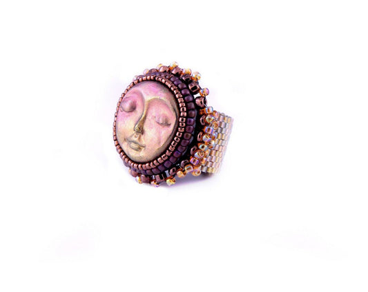Side profile of sun face cuff ring with gold and purple seed beading with gold seed bead band.