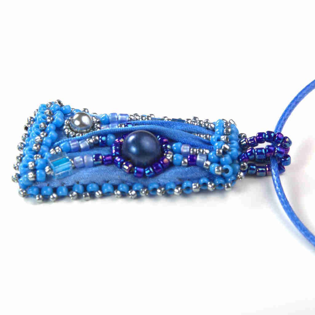 Side profile of Blue shibori silk and beaded pendant right