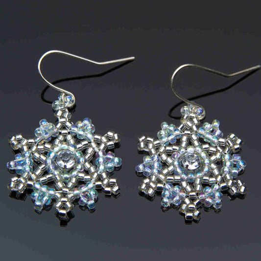 large seed beaded snowflake earrings in blue and silver on a gray background