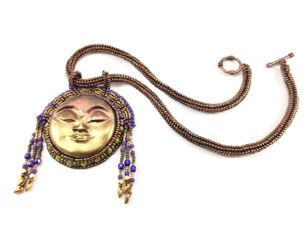 Flat lay view of the Egyptian sun goddess statement beaded gold art necklace with beaded headdress.