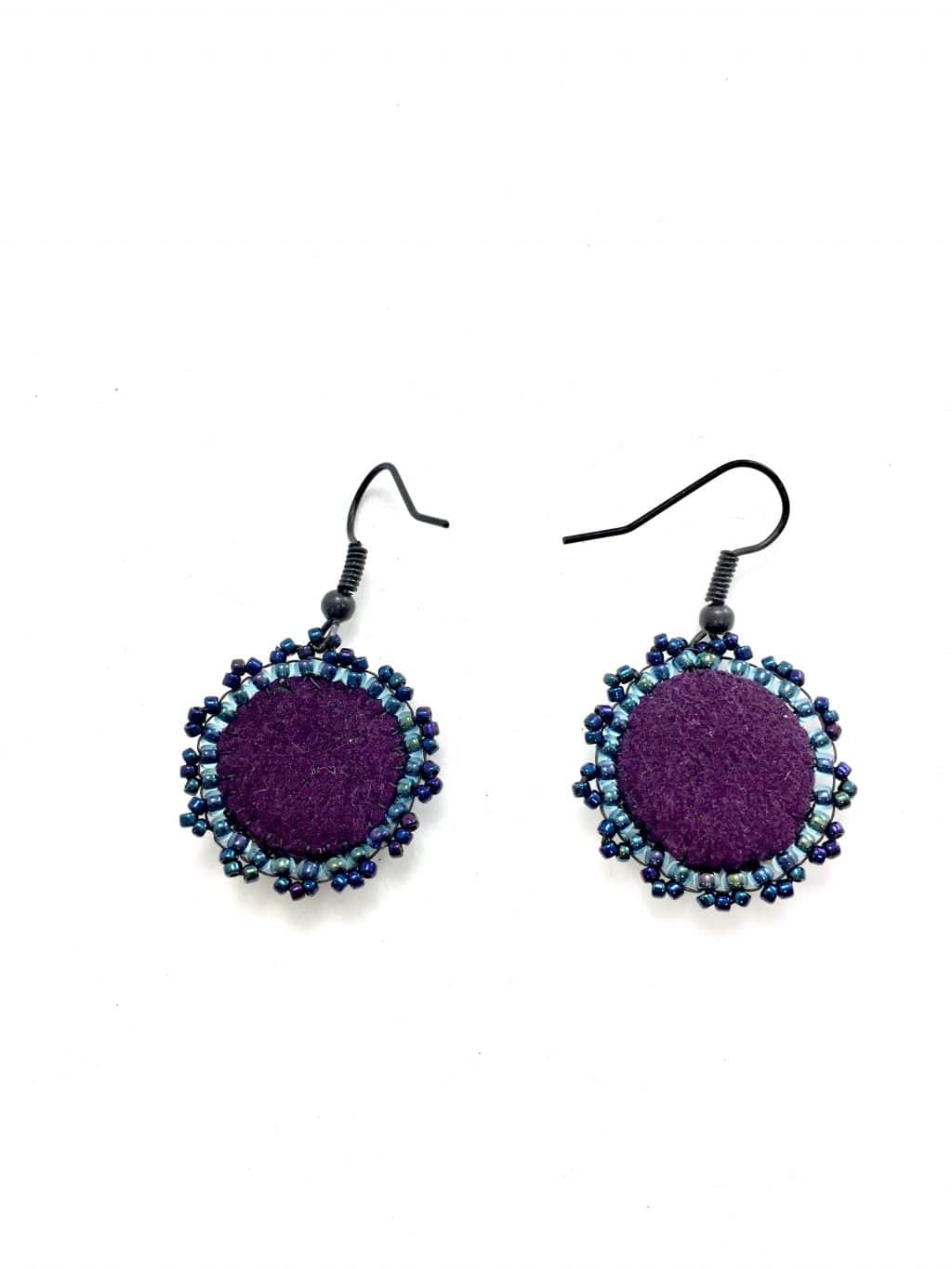 Back of blue moon face earrings with purple faux suede and blue seed beaded edging.