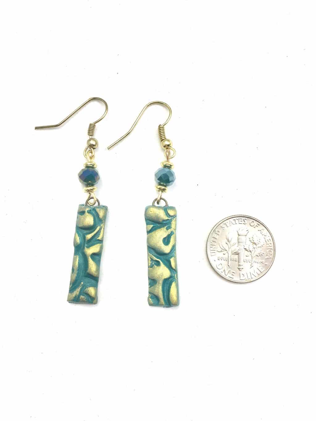 teal and gold bar earrings with a quarter next to them for size reference.