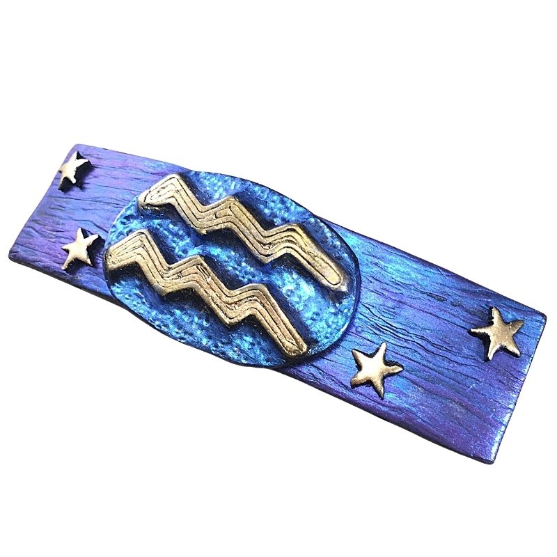 Side profile of Blue hair clip with Aquarius zodiac sign in gold with gold stars.