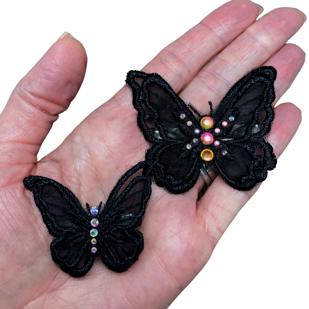 Black applique butterfly alligator hair clips with your choice of crystals shown in hand for size reference.