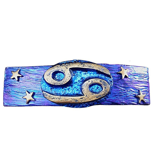 A blue and purple barrette with a gold cancer zodiac sign with stars either side