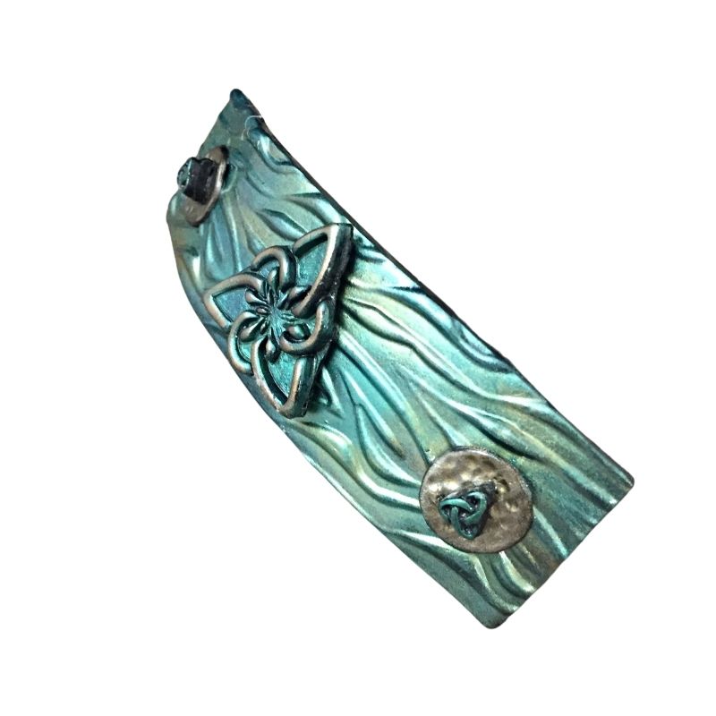 Left profile view of 3 triquetras on a green and gold hair barrette.