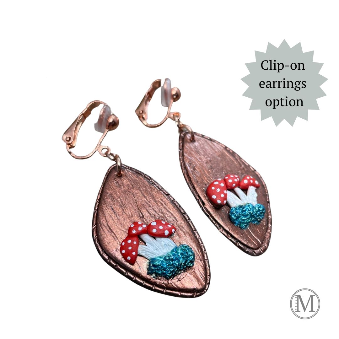 Geometric shaped bronze clay clip-on dangle earrings with small clusters of Amanita mushrooms
