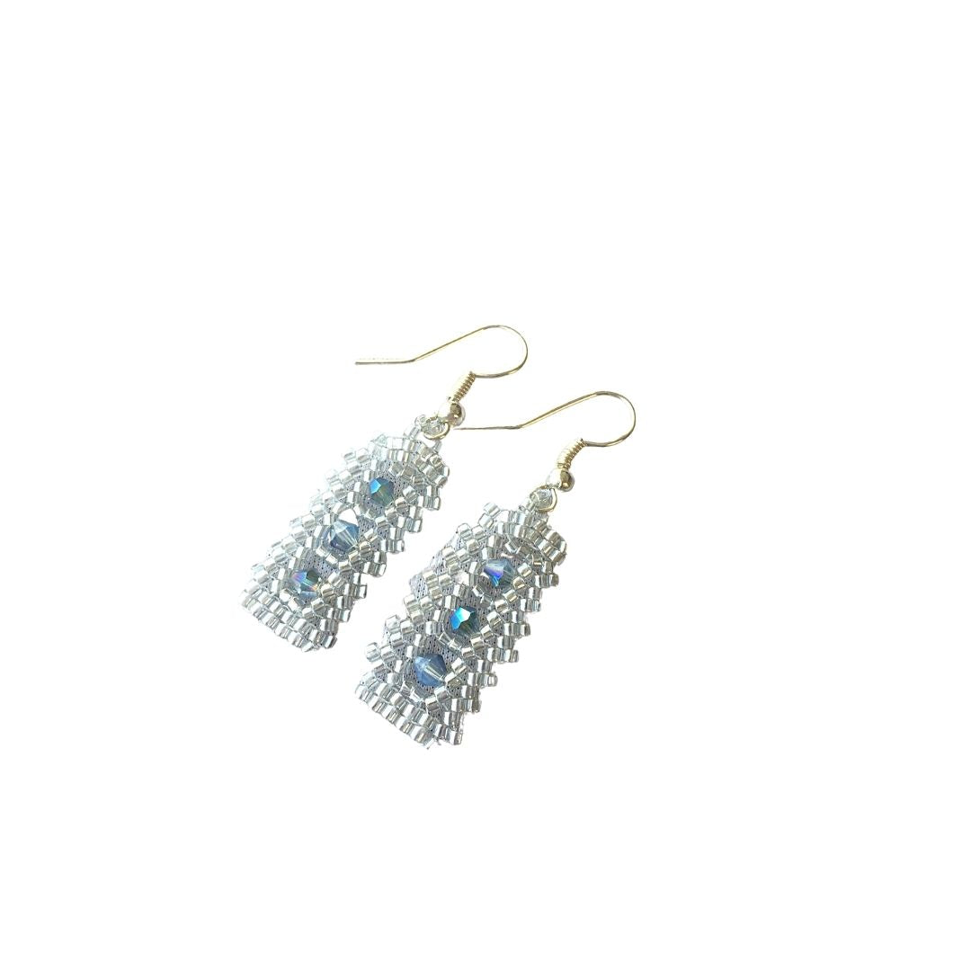 Silver crystal beaded bar earrings with pale blue crystals in the center in a vertical row.