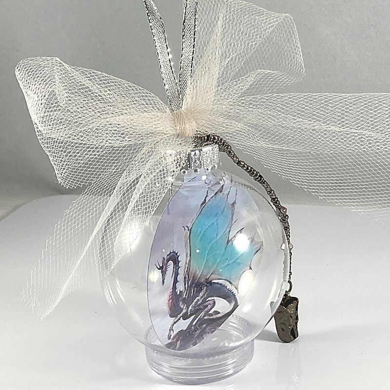 Side view of dragon christmas floating ball ornament with dragon charm and tulle bow.