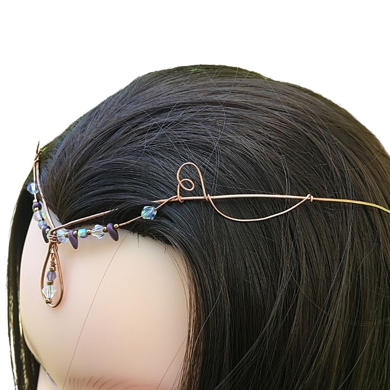 Left profile view of model wearing teardrop crystal forehead tiara copper crystal diadem.
