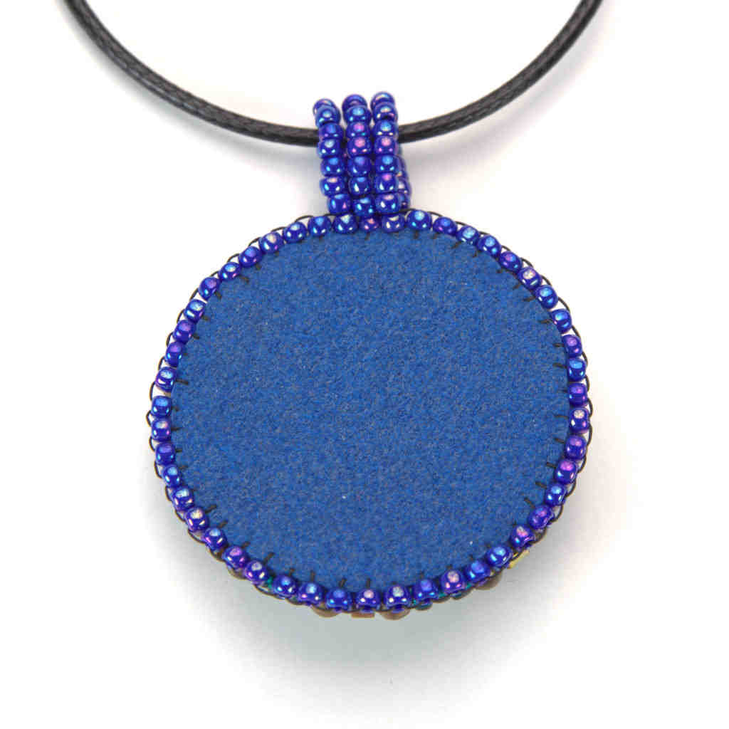 Back of mandala pendant with blue faux suede.