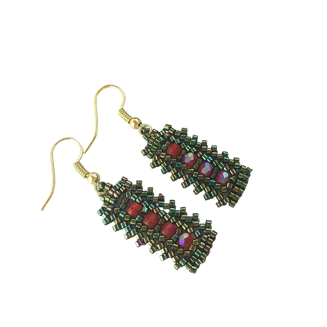 Side profile green seed beaded bar earrings with red crystals in a central row.