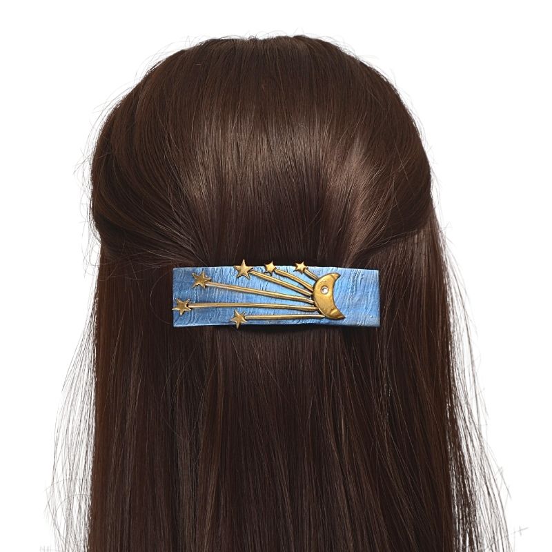 Blue hair barrette with gold crescent moon and starburst in model’s hair