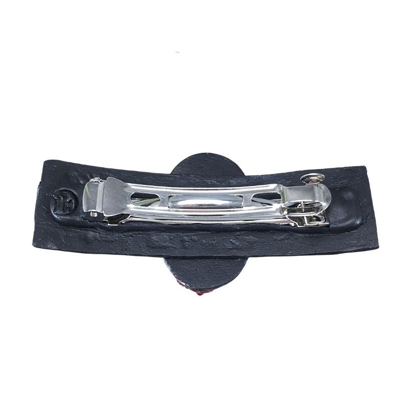 Back of silver skeleton cameo polymer clay hair barrette with red flowers and red crystals with a black textured base highlighted silver.