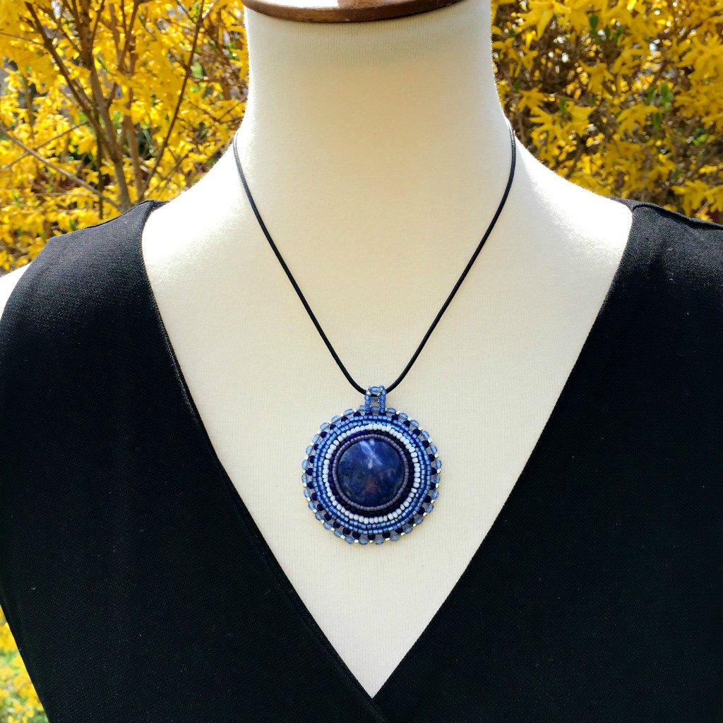 sodalite blue gemstone necklace with blue silver and white beading displayed on a mannequin.