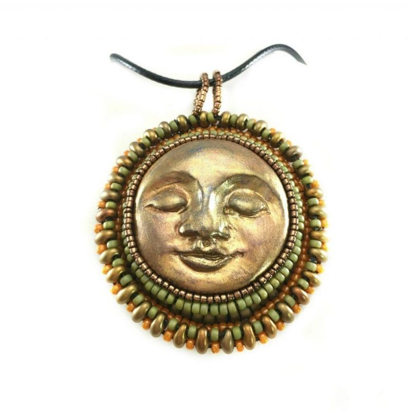 sun face round pendant in gold with green, gold and orange beaded edging.