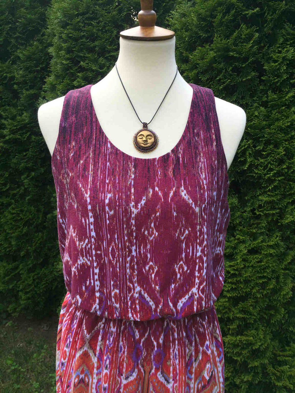 sun face round pendant in gold with burgandy and iradescent beaded bezel