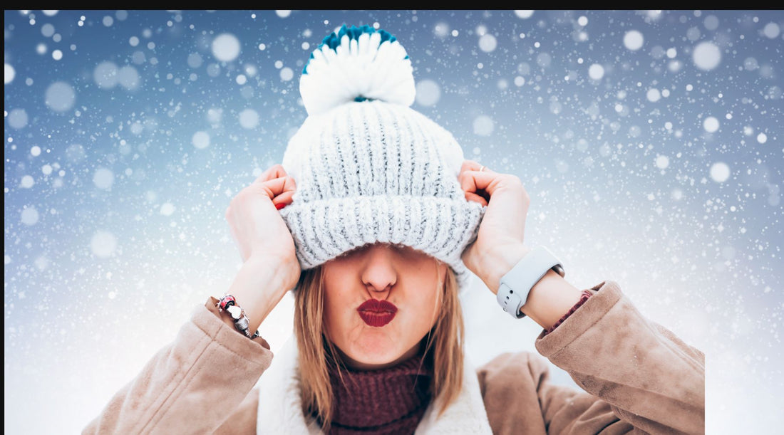 A women pulling an anguished look as she attempts to take of her winter hat.