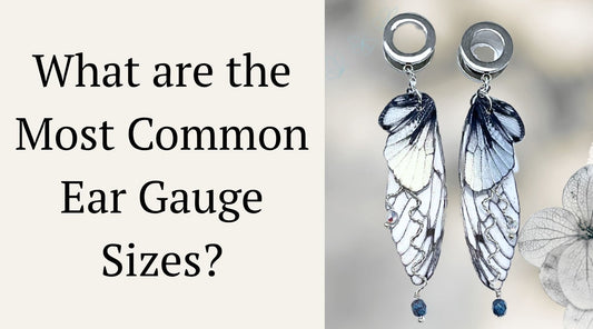 Silver fairy wing ear gauges on a beige flower background with  blog title to the left