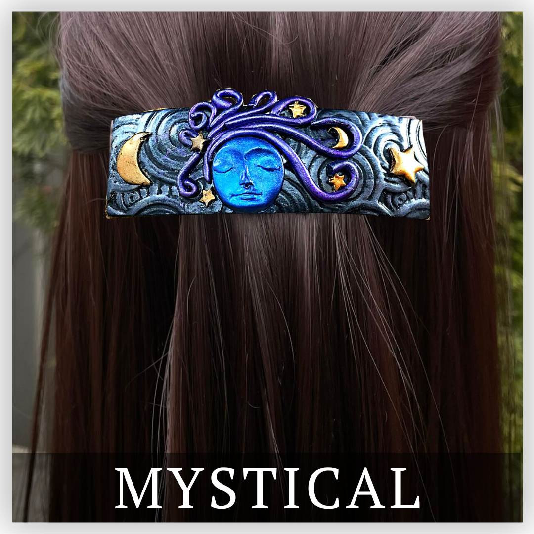 Black and silver clay Death's head moth hair clip on blue base with a gold moon and star either side of the moth.