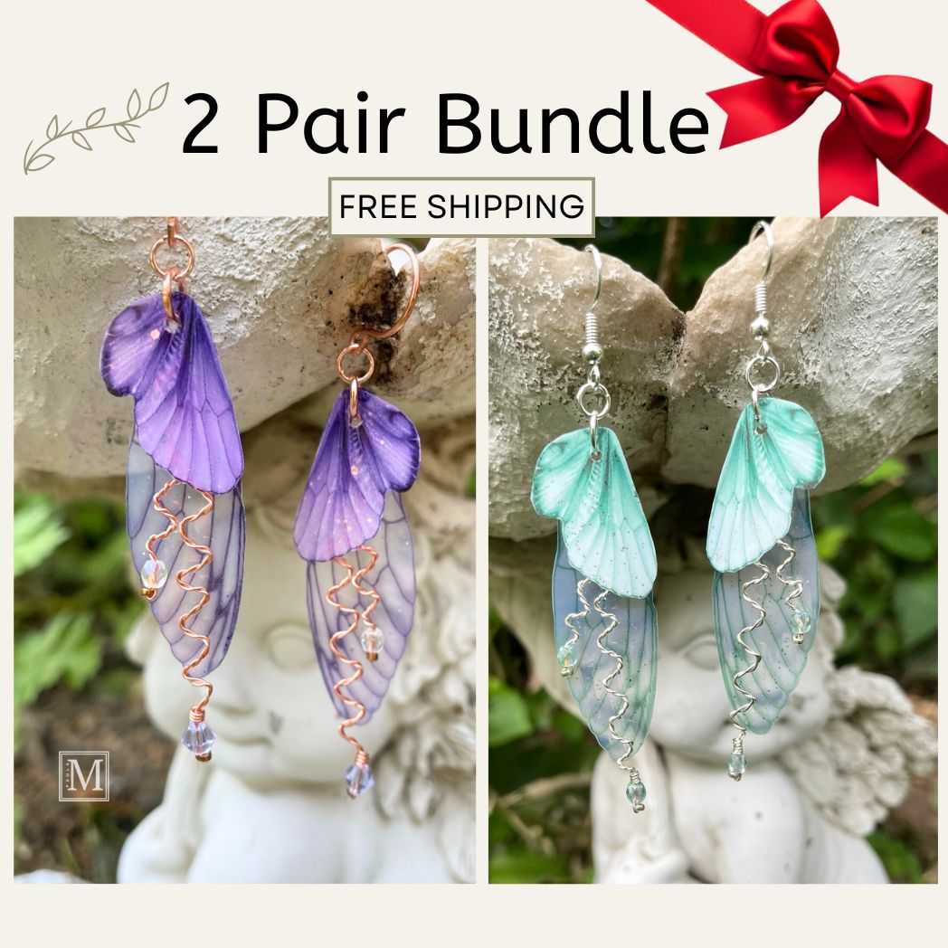 Two pairs of colorful earrings with a red bow on a stone surface.