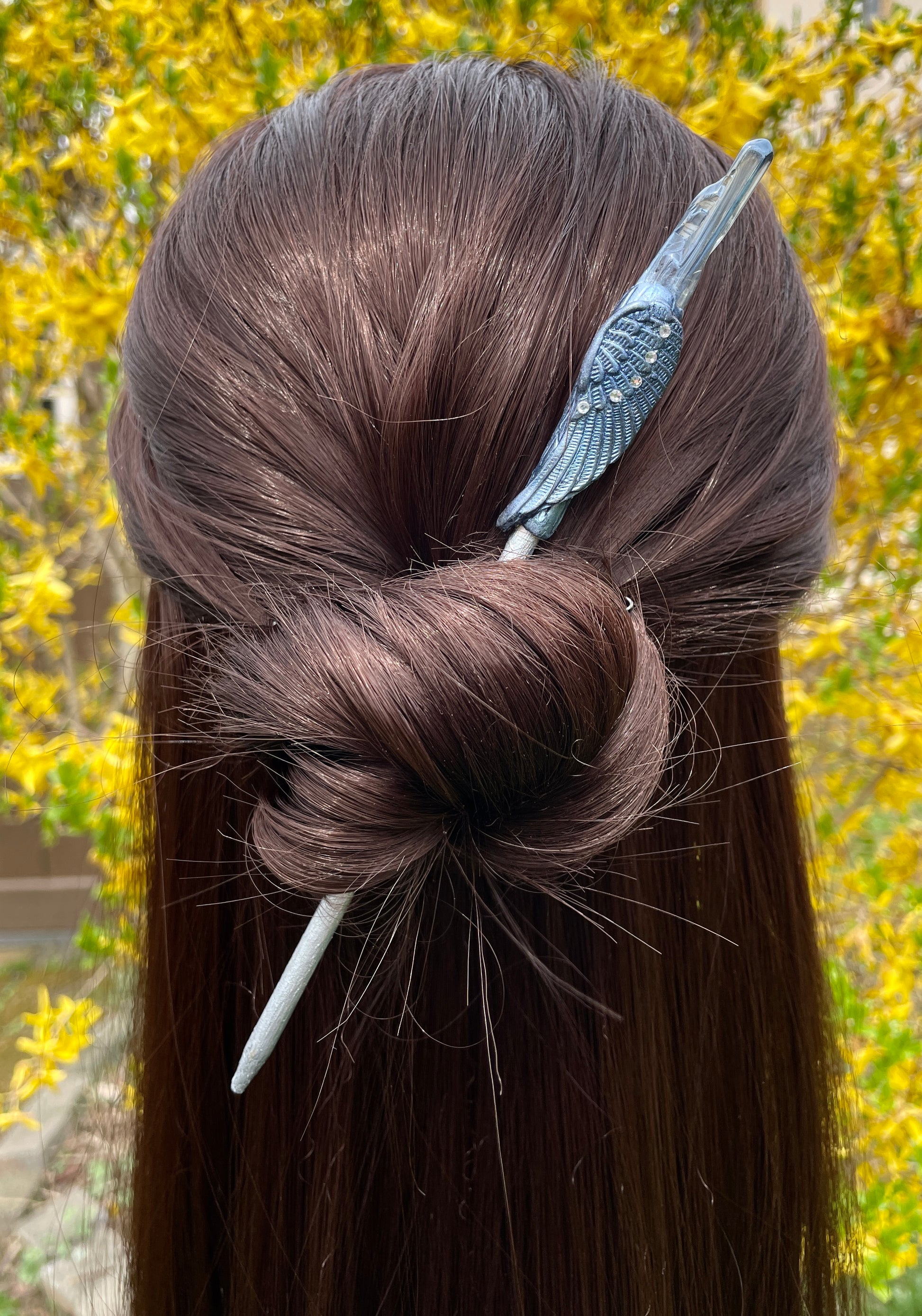 Blue/silver Angel wing hair stick with quartz crystal hair stick on a model.