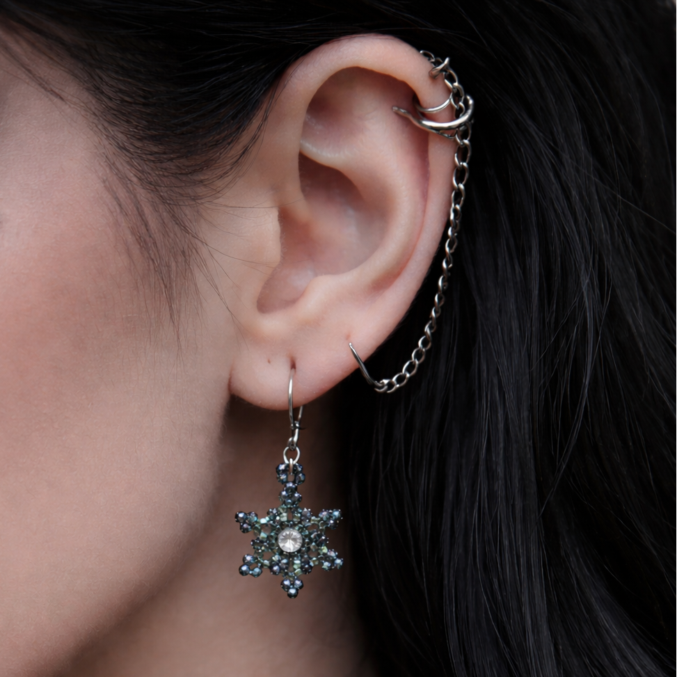Close-up of an ear with a star-shaped earring and black lace choker.