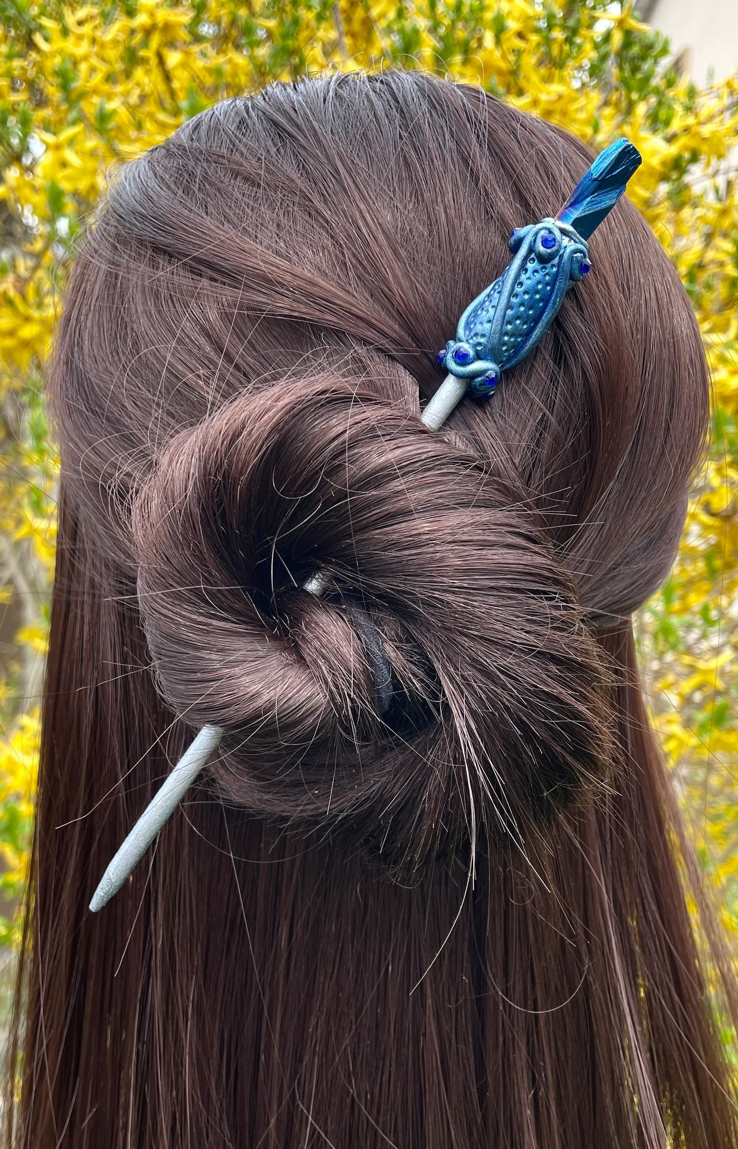 Model wearing blue raw crystal hair stick with hand painted clay details and crystals.